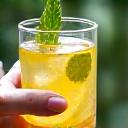 Ruka držící sklenici vody s citronem a zázvorem, symbolizující posílení imunity